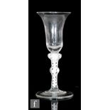 An 18th Century drinking glass circa 1765, the bell bowl above a double series opaque twist stem