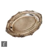 A Victorian hallmarked silver oval platter of plain form with leaf detail to scroll border, length