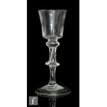 An 18th Century wine glass circa 1750, the bucket bowl above a three knopped and teared stem, raised