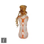 A continental silver gilt waisted scent bottle with pink overlaid decoration terminating in gilded