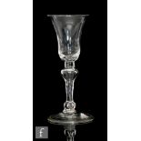 An 18th Century wine glass circa 1730, the bell bowl above a teared inverted baluster and basal