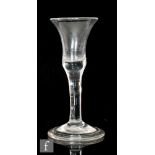 An 18th Century wine glass circa 1740, the waisted bell bowl with solid base over a plain stem and