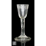 An 18th Century wine glass circa 1740, the round funnel bowl engraved with a floral band above a