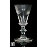 An 18th Century drinking glass circa 1780, the deceptive funnel bowl with basal bladed knop over a