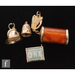 Five assorted 9ct charms, a ten shilling, a one pound, a fireman's helmet, a thimble and a harp,