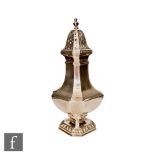 A hallmarked silver sugar caster, canted square base below octagonal flaring body and pierced cover,