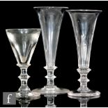 Two drinking glasses circa 1800, each with a tall trumpet bowl, one with basal fluting, each above