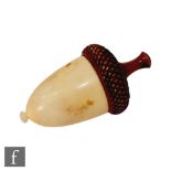 A late 19th Century thimble case formed as an acorn with a carved wooden top and a vegetable ivory