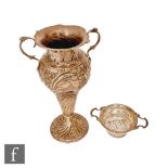 A hallmarked silver twin handled trumpet vase with embossed foliate decoration, height 20cm, with