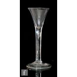 An 18th Century wine glass circa 1740, the trumpet bowl above a teared stem, raised to a folded