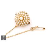 A Victorian 9ct circular dome shaped brooch with three rows of split seed pearls encompassing