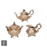 A 19th Century continental silver three piece tea set of part wrythen form with embossed foliate