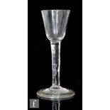 An 18th Century wine glass circa 1740, the round funnel bowl above a plain stem, raised to a