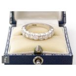 A mid 20th Century 18ct white gold diamond half eternity ring, comprising nine claw set brilliant