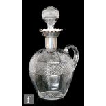 An early 20th Century glass and hallmarked silver claret jug, the ovoid body cut with a band of