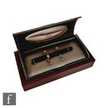 A boxed Parker Duofold roller ball pen in black with 23k gold plated trim.