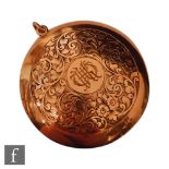 An early 20th Century 9ct rose gold circular compact with central initials within engraved foliate