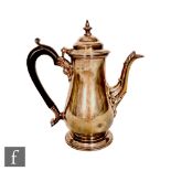 A hallmarked silver coffee pot of plain baluster form terminating in scroll wooden handle, height