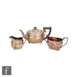 A hallmarked silver three piece boat shape tea set of plain form with dart detail to borders,