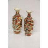 A pair of cream ground Japanese Warrior Vases, with shaped rims, and decorated in relief,