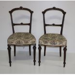 A set of four walnut open back carved Salon Chairs, covered in floral cream fabric on tapering legs.