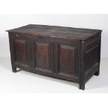 An 18th Century carved oak Coffer, the three plank lift top over panelled sides,
