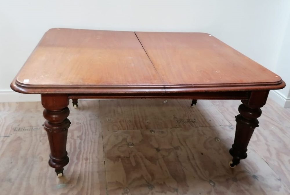 A large Victorian mahogany Dining Table (dismantled) with two spare leaves on heavy turned and