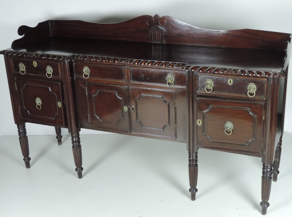 An early 19th Century mahogany inverted breakfront Sideboard, with shaped back,