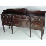 An early 19th Century mahogany inverted breakfront Sideboard, with shaped back,