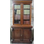 An elegant early Victorian period mahogany Bookcase, the figured cornice over two glazed doors,