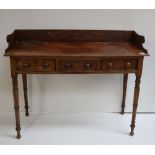 A late Georgian mahogany Dressing Table, with shaped back over three frieze drawers on turned legs.