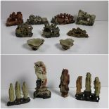 A collection of 19th Century Chinese soapstone Immortals, mounted in threes on naturalistic stands,
