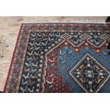 An Ashak dark blue and claret ground Carpet, with geometric central panels and thin floral border.
