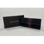 A black canvas Pochette, bearing Gucci e