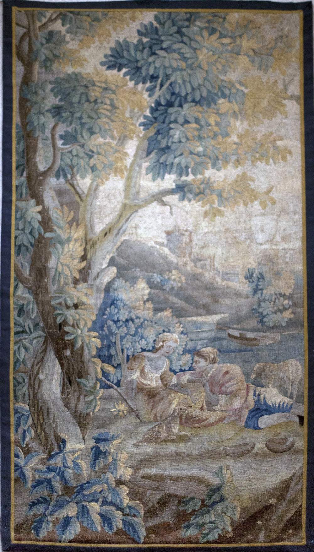 A fine 18th Century French polychrome Verdure Tapestry, with figures resting in a landscape,