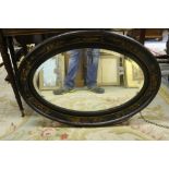 An oval black lacquered and chinoiserie decorated Wall Mirror, with bevelled plate,