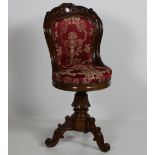 A Victorian mahogany Music Chair, the curved back carved with scrolling foliage,