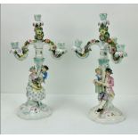 A fine pair of Sitzendorf figural porcelain three branch, four light Candelabra,