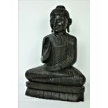 A late 19th Century / early 20th Century carved wooden seated Buddha,