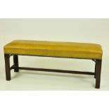 A good Georgian mahogany long Stool, in lemon coloured leather,