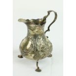 A small English Victorian silver Cream Jug, decorated with scrolls, flowers and leaves,