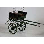 An unusual 19th Century painted "Dog Trap", with folding drop seat on painted spoke wheels.