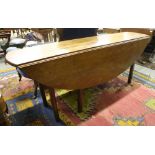 A Georgian style mahogany drop leaf Wakes or Hunt Table, with D end flaps on square legs,