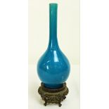 A Chinese turquoise (blue) glazed Bottle Neck Vase, 25cms (10") high, on a carved hardwood stand.