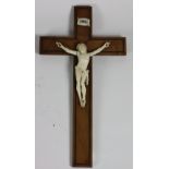 A fine carved ivory Corpus Christi, on brass inlaid mahogany cross, 16" x 8 1/4" (41cms x 21cms).