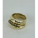 A triple band gold Ladies Ring, with beaten effect design, set with fine 'emerald' type stones.