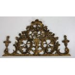 An ornate carved giltwood Overdoor in the rococo style, carved and pierced with C scrolls,