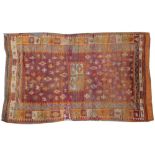 A semi-antique Indian Kilim, with dark red ground with a centre four panel rectangular medallion,