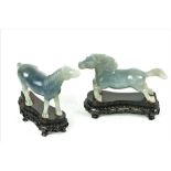 A cased pair of 20th Century Chinese Celadon jade carved Horses, on hardwood pierced bases,