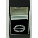 An attractive 18ct white gold oval Brooch Set, with 10 sapphires (.